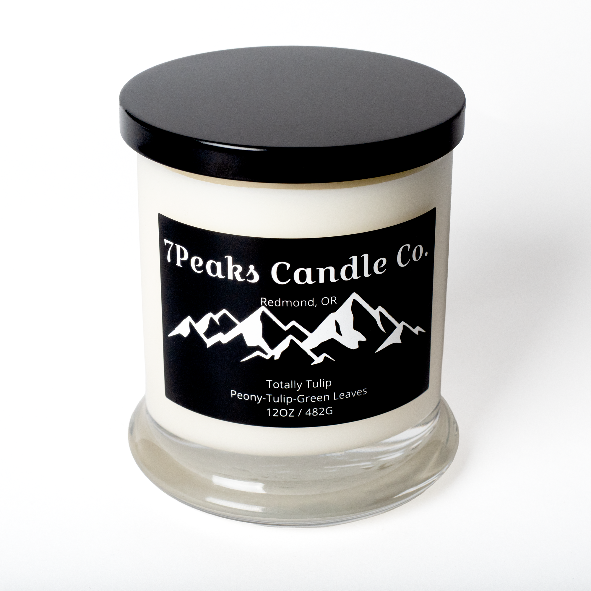 Picture of a white candle in a clear glass jar with a black lid.