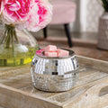 Disco Ball Wax Warmer shaped like mirror ball with silver finish on tabletop